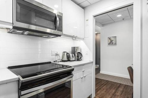 a kitchen with a stove and a microwave at The Mountain Loft in Canmore