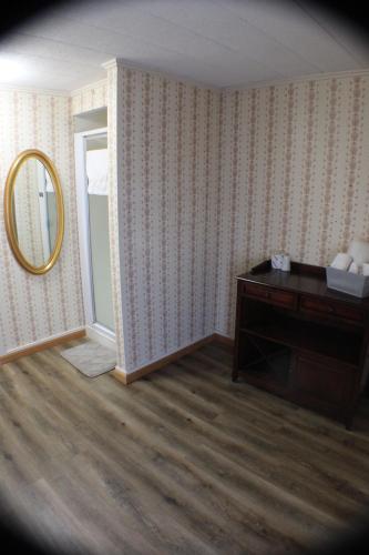 a room with a mirror and a dresser in a room at Historical Hotel - House of Ludington in Escanaba