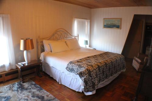 a bedroom with a large bed and two windows at Historical Hotel - House of Ludington in Escanaba