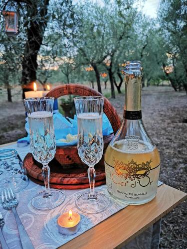 a bottle of wine and two glasses on a table at La casa dei nonni in Larciano