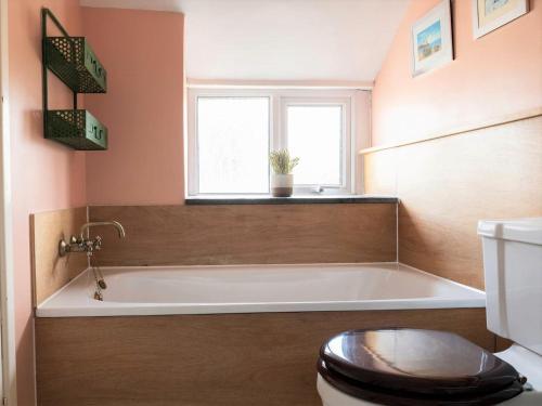 ein Badezimmer mit Badewanne und Toilette und einem Fenster in der Unterkunft Charming 2 bed Escape in Snowdonia National Park ! Nr Betws y Coed in Betws-y-coed