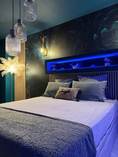 - une chambre avec un grand lit et un éclairage bleu dans l'établissement Flower Suite and Spa, à La Seyne-sur-Mer