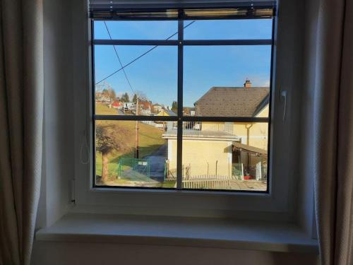 ein Fenster mit Blick auf ein Haus in der Unterkunft Wohnen in Graz Mariatrost in Graz