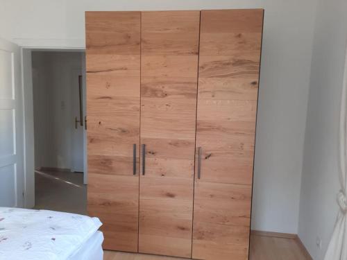 a large wooden cabinet in a bedroom with a bed at Wohnen in Graz Mariatrost in Graz