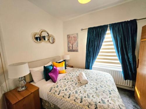 Un dormitorio con una cama con almohadas de colores y una ventana en Splendid Stay By Sensational Stay Short Lets & Serviced Accommodation At Manor Street, en Belfast