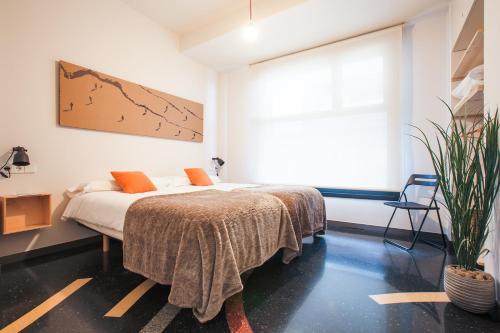 1 dormitorio con cama y ventana grande en Apartamentos Dada, en Zarautz