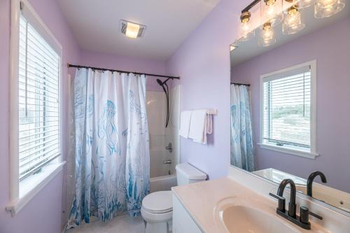 a bathroom with a sink and a toilet and a mirror at Ocean Aire in Knotts Island