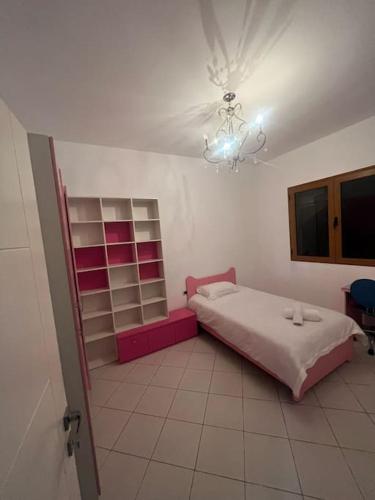 Schlafzimmer mit einem Bett und einem Kronleuchter in der Unterkunft City view in Elbasan
