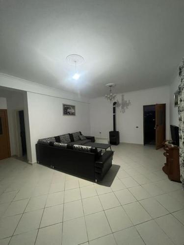 ein Wohnzimmer mit einer schwarzen Couch in einem Zimmer in der Unterkunft City view in Elbasan