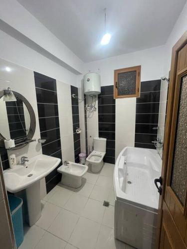a bathroom with a sink and a tub and a toilet at City view in Elbasan
