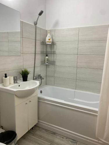 a bathroom with a white tub and a sink at Studio 1 MEGA MALL National Arena in Bucharest