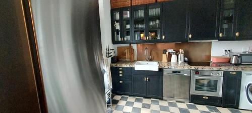 une cuisine avec des armoires noires et un sol en damier dans l'établissement SEÑORIO DEL CADOSO, à Carmona