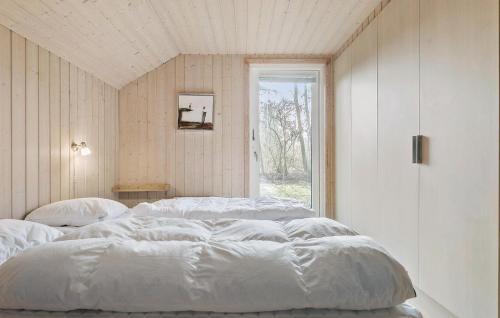 two beds in a room with a window at Holiday Home Bæverstien Dnmk Iv in Marielyst
