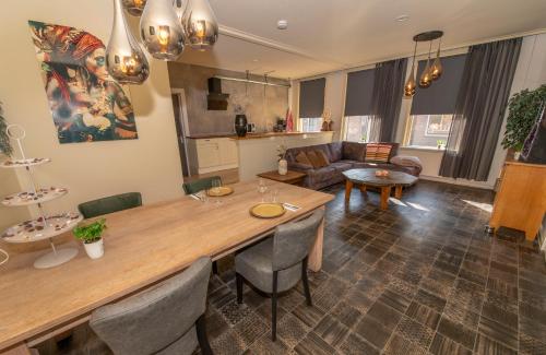 a kitchen and living room with a table and chairs at Appartement Carlijn in Diever