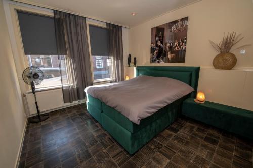 a bedroom with a green bed and a window at Appartement 1 in Diever