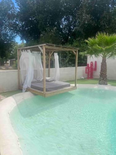 - un lit au milieu d'une piscine d'eau dans l'établissement Avignon La maison des roses 4, à Villeneuve-lès-Avignon