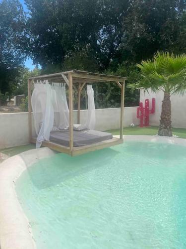 - un lit au milieu d'une piscine d'eau dans l'établissement La maison des roses 4 Avignon, à Villeneuve-lès-Avignon