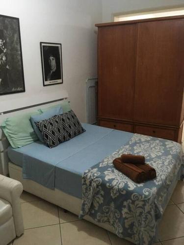 a bedroom with a bed and a cabinet at Av Atlântica - Beira Mar de Copacabana - posto4 in Rio de Janeiro