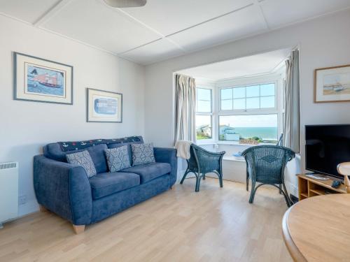 a living room with a blue couch and chairs at Pinewood Flat 5 in Polzeath