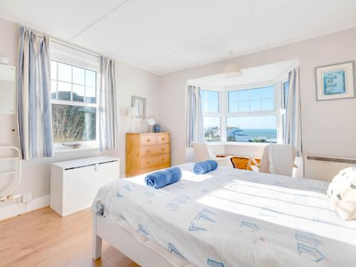 a bedroom with a large bed and two windows at Pinewood Flat 5 in Polzeath