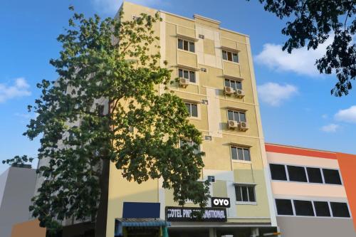 ein hohes Gebäude mit einem Baum davor in der Unterkunft Super Collection O Hotel Pnr International Mehdipatnam in Hyderabad