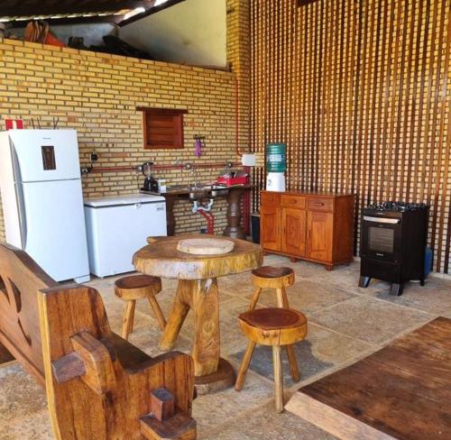 uma cozinha com uma mesa de madeira e bancos em pousada Baloiço em Caucaia