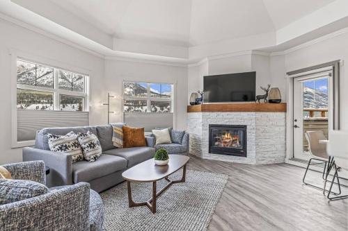 a living room with a couch and a fireplace at Mountain Vista Escape Downtown in Canmore