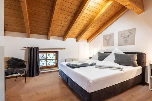 a bedroom with a large bed and a window at MyWinkl Design-Ferienwohnungen in Reit im Winkl