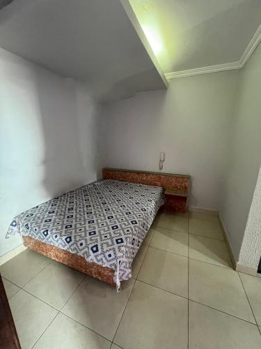 a bedroom with a bed in the corner of a room at Pousada Azul Ms in Viracopos