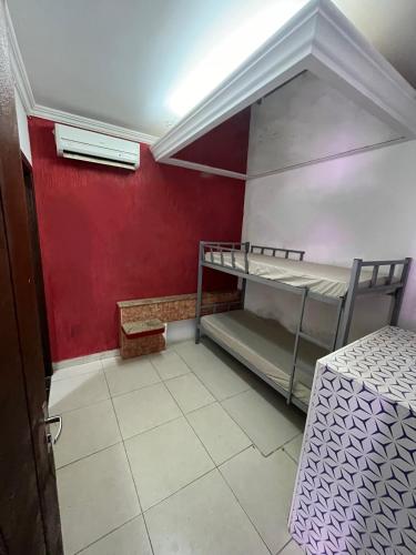 a room with two bunk beds and a red wall at Pousada Azul Ms in Viracopos