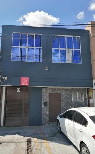 un coche blanco estacionado frente a un edificio en Comfort Home Escalón en San Salvador