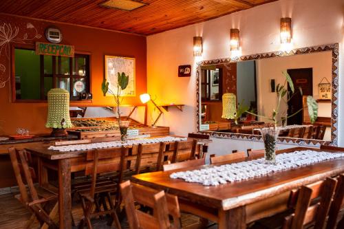 a dining room with a table and a mirror at Pousada Tatu Feliz in Vale do Capao