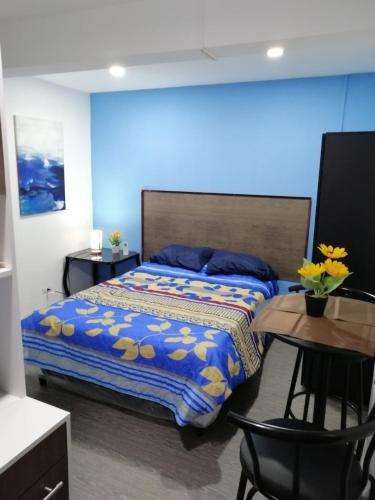 a bedroom with a bed and a table with a tableablish at Comfort Home Escalón in San Salvador