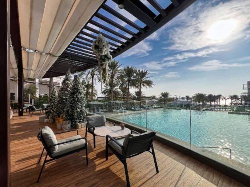 a patio with a swimming pool with chairs and avationliest at Luxury the address 3BR in Fujairah