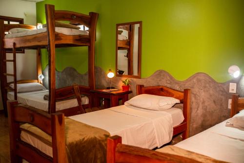 a bedroom with two bunk beds and a green wall at Pousada Tatu Feliz in Vale do Capao