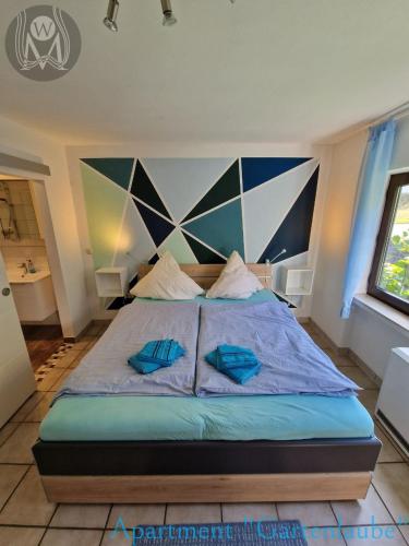 a bedroom with a large bed with blue pillows at Weingut im Moselkrampen in Ellenz-Poltersdorf