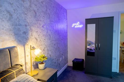 a room with a bed and a purple wall at 1 Bedroom Apartment - Netflix - Close To City Centre And NEC in Birmingham