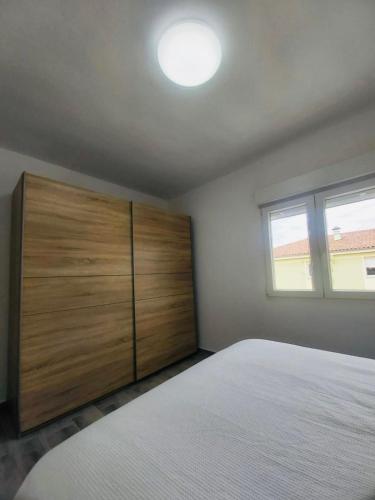 una camera con un letto e un grande armadio in legno di Descubre Cantabria! Piso con 3 habitaciones, con capacidad hasta 5 personas! Alojamiento entero! a Sarón