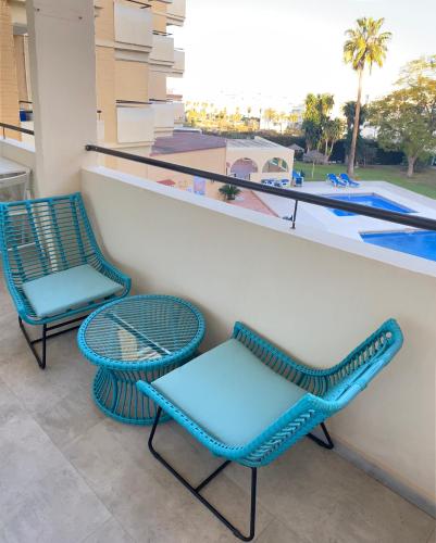 2 stoelen en een tafel op een balkon met een zwembad bij Sea City Torremolinos Golf in Torremolinos