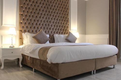 a bedroom with a large bed with a large padded headboard at الماطر للشقق الفندقية Almater Hotel Suites in Khafji