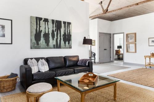 a living room with a black couch and a table at The Barns of Brighton Near Prince Edward County in Brighton