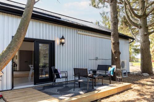a patio with a table and chairs next to a building at The Barns of Brighton Near Prince Edward County in Brighton