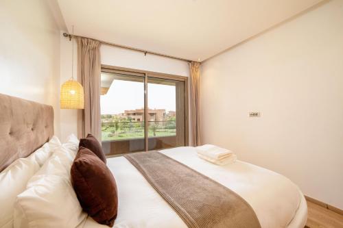 sypialnia z dużym łóżkiem i oknem w obiekcie Vue Imprenable golf-Piscine w Marakeszu