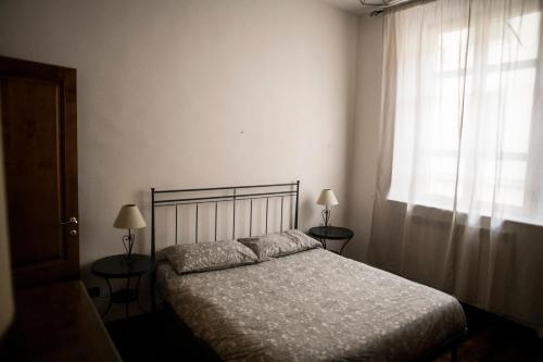 a bedroom with a bed with two lamps and a window at Carla e Lui a Livorno in Livorno