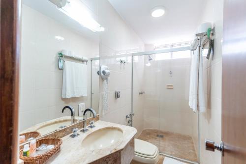 a bathroom with a sink and a shower and a toilet at Copas Verdes Hotel in Cascavel