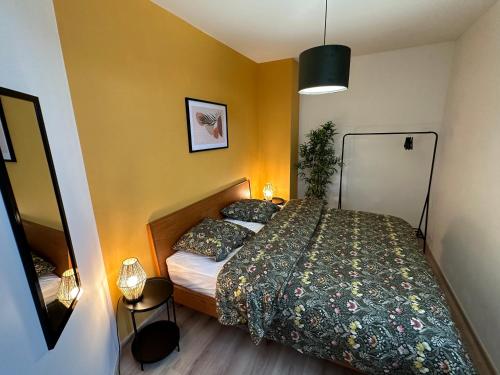 une petite chambre avec un lit et un miroir dans l'établissement Charmante Maison de 3 Ch avec Jardin et Parking, à Saint Pierre Les Elbeuf
