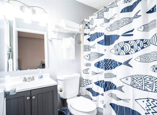 a bathroom with a blue and white fish shower curtain at Tribesman #18 - Mr Brightside - on Table Rock Lake in Branson