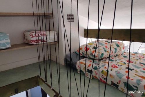 klatka z łóżkiem w pokoju w obiekcie Charmant appartement T2 de 36m² au cœur du village w Saintes-Maries-de-la-Mer