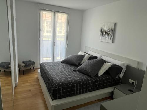 a bedroom with a bed in a white room at Apartamento moderno y acogedor ideal familias in Orio