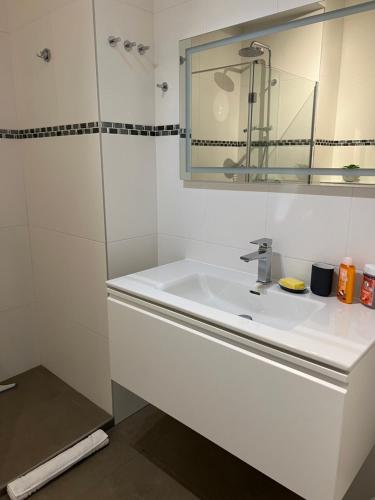 een witte badkamer met een wastafel en een spiegel bij Croisette Palais Miramar - sea view in Cannes